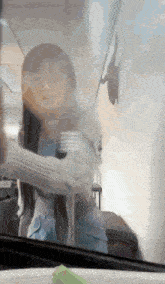 a woman in a white sweater is standing in a room