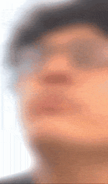 a blurry photo of a person 's face with glasses