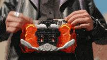 a man in a black jacket is holding a toy that says ' samurai ' on the front