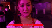 a woman is standing in a dark room with a red sign that says ' i 'm sorry ' on it .