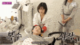 a woman in a white coat is washing another woman 's hair and says " starting revenge " on the bottom