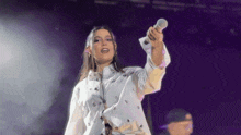 a woman is singing into a microphone on stage