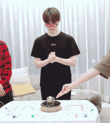 a man wearing a black shirt with the number 21 on it stands in front of a cake