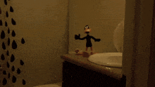 a bathroom with a toilet sink and a duck figurine