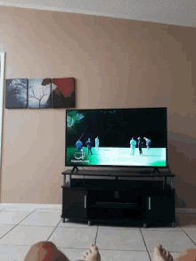 a flat screen tv is hanging on a wall with a green screen that says adventures