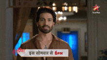 a man with a beard stands in front of a star plus logo