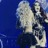 two women singing on a stage with rbd3d written on the bottom right