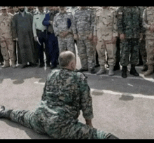 a man in a military uniform is kneeling down in front of a group of soldiers