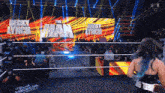 a woman with blue hair is entering a wrestling ring