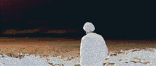 a man is standing on top of a hill overlooking the ocean .