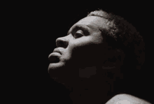 a close up of a man 's face looking up in the dark