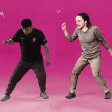 two men are dancing in front of a pink background and one has a shirt that says new zealand