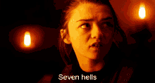 a woman in a dark room with the words seven hells behind her