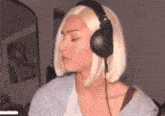 a woman wearing headphones and a wig is sitting in a room .