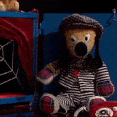 a stuffed animal sitting next to a red telephone