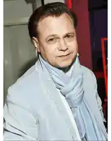 a man wearing a striped jacket and a blue scarf