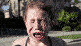 a young girl with red hair is crying with her eyes closed