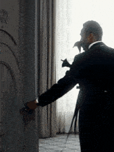 a man in a suit opens a door with the number 10 on the wall