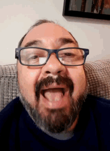 a man with glasses and a beard makes a funny face