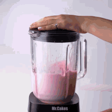 a mr.cakes blender is being used to make a pink smoothie