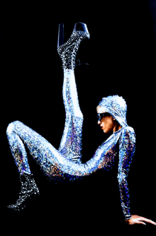 a woman in a silver bodysuit is laying on the floor