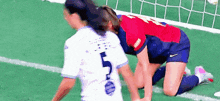 two women are playing soccer on a field .