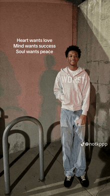 a young man wearing a hoodie that says worst is standing in front of a wall