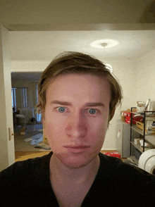 a man 's face is shown in front of a shelf with boxes on it