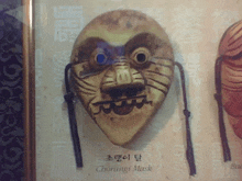 a chorangi mask is displayed on a wall with other masks