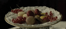 a plate with macarons and berries on it