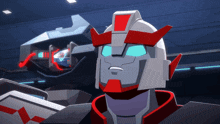 a robot with a red head and blue eyes is standing in a room