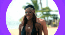 a woman wearing a black bikini and a cross necklace smiles