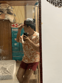 a man taking a selfie in front of a mirror with a sign above him that says ' a '