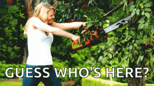 a woman is cutting a tree with a chainsaw and the words `` guess who 's here '' below her .