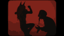 a shadow of a person with a horn on their head standing next to another person 's hand .
