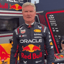 a man wearing a red bull racing suit