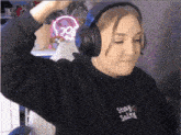 a girl wearing headphones and a black sweatshirt that says stay salty