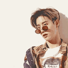 a young man wearing sunglasses and a t-shirt that says roken on it