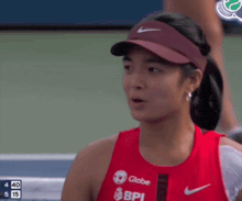 a woman wearing a red tank top that says globe bpi on it