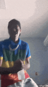 a man wearing a multicolored polo shirt with the letter y on it