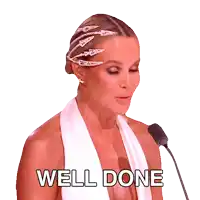 a woman in a white dress stands in front of a microphone with the words well done behind her