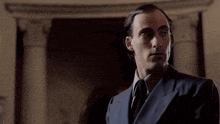 a man in a suit and tie is standing in a room