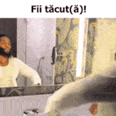 a man in a white shirt is looking at himself in a mirror with the caption fii tacut ( a ) !