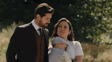 a man and a woman standing next to a baby