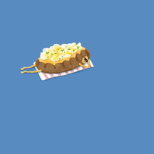 a stuffed potato laying on a checkered napkin on a blue background