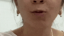 a close up of a woman 's face with earrings on .