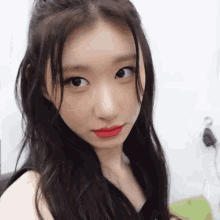 a close up of a woman with long hair and red lipstick .