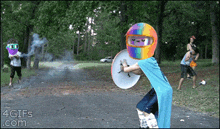 a boy wearing a rainbow helmet is holding a shield and a sword