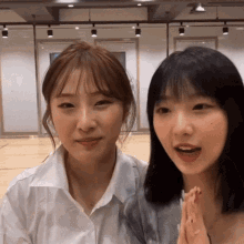 two girls are sitting next to each other and smiling