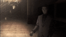 a man in a suit and tie is walking in a dark room